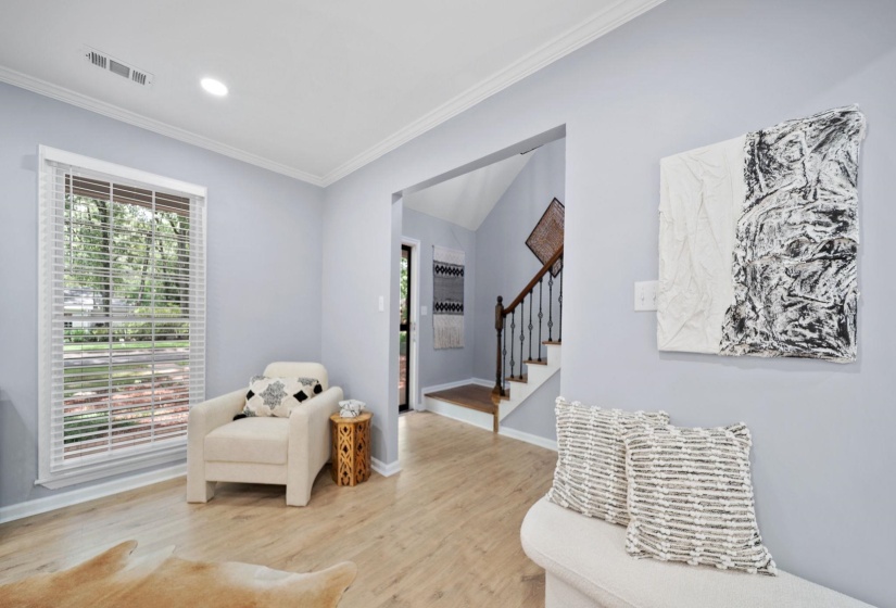 Interior living area featuring light wood-finish flooring, light blue walls, and white crown molding