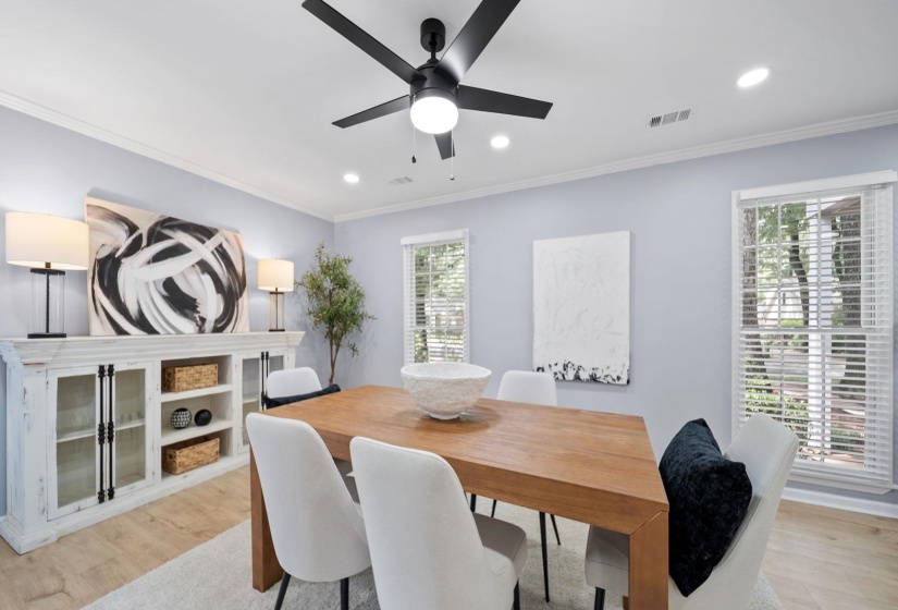 Light wood-finish flooring complements the crown molding and recessed lighting