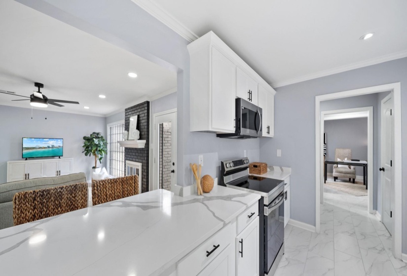 Kitchen featuring white cabinetry, stainless steel appliances, and a quartz countertop with subtle veining