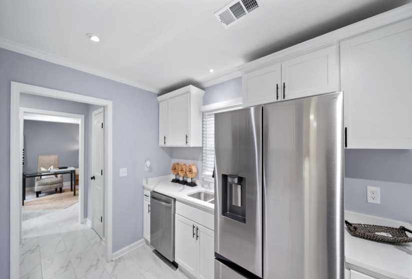 Contemporary kitchen featuring white cabinetry, stainless steel appliances, and white countertops