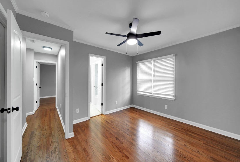 Unfurnished bedroom with wood finished floors, ornamental molding, and ceiling fan