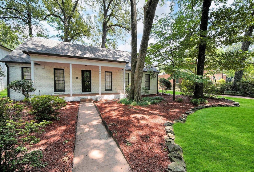 View of front of property featuring brick siding, a front yard, a porch, and a shingled roof