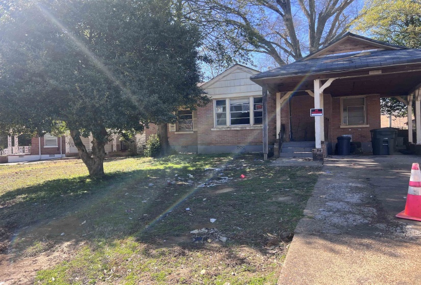 View of front facade featuring brick siding, a front yard, and covered porch