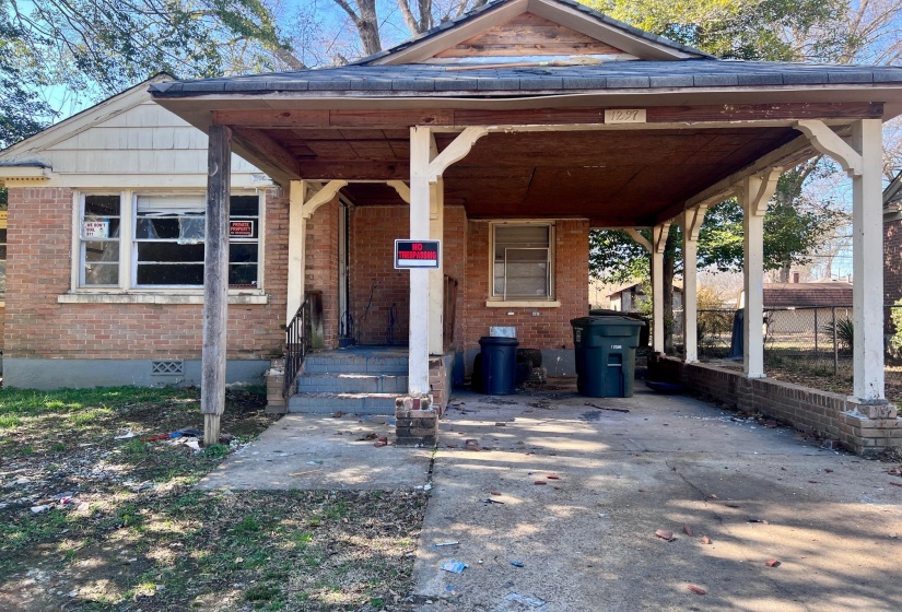 Entrance to property with a porch, brick siding, and crawl space
