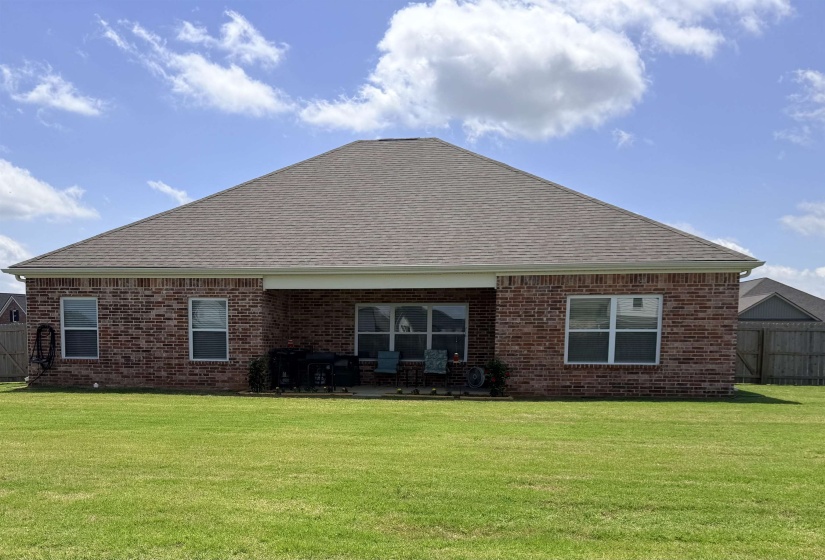 Brick exterior featuring a gabled roofline, covered patio, and multiple windows