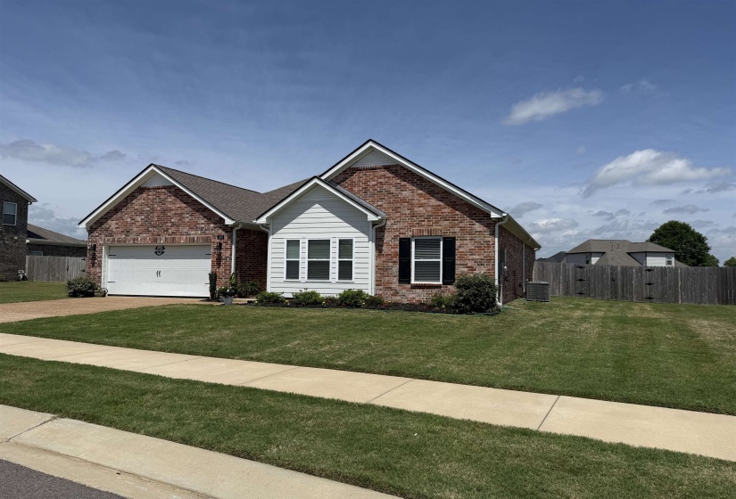 Brick and siding exterior featuring an attached garage, a bay window, and a concrete driveway