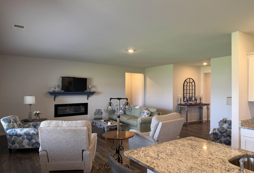 Open-concept living area featuring a built-in electric fireplace with a floating mantel