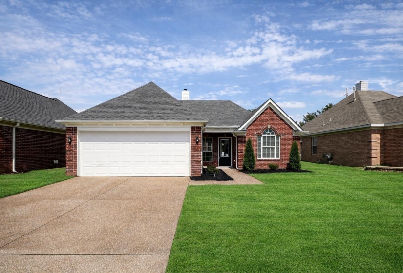 Brick exterior featuring a gabled roofline and attached garage