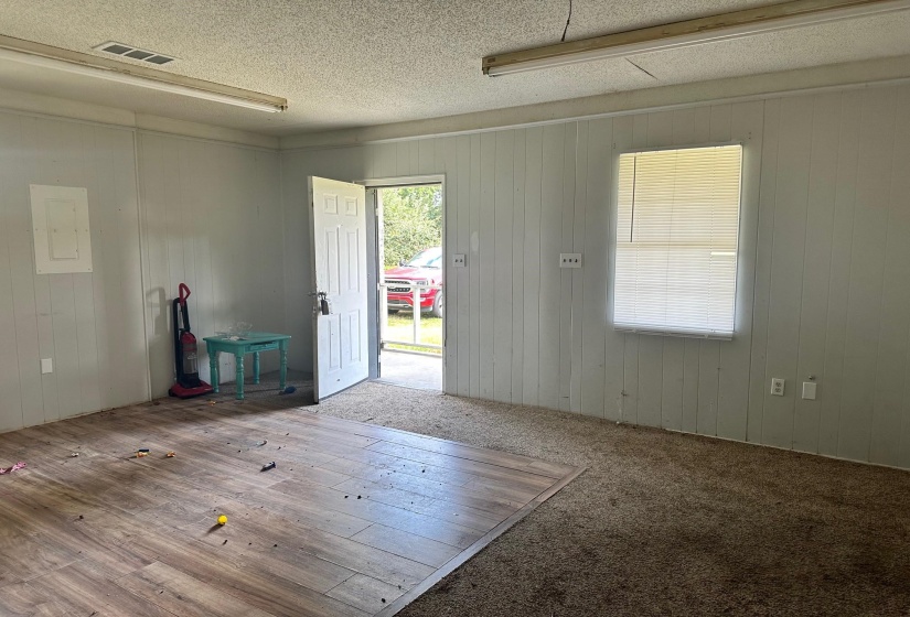 Empty room with a textured ceiling, hardwood / wood-style floors, and electric panel