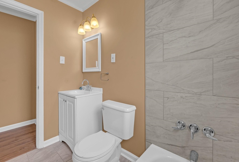 Bathroom featuring a white vanity with integrated sink, chrome faucet, and white framed mirror