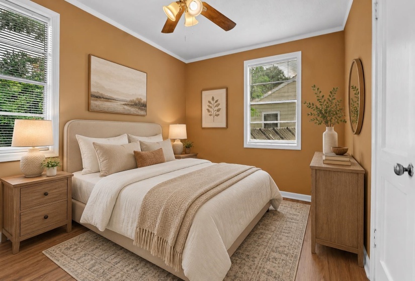 Warm-toned bedroom featuring wood-finish flooring, white window blinds, and a ceiling fan with integrated lighting