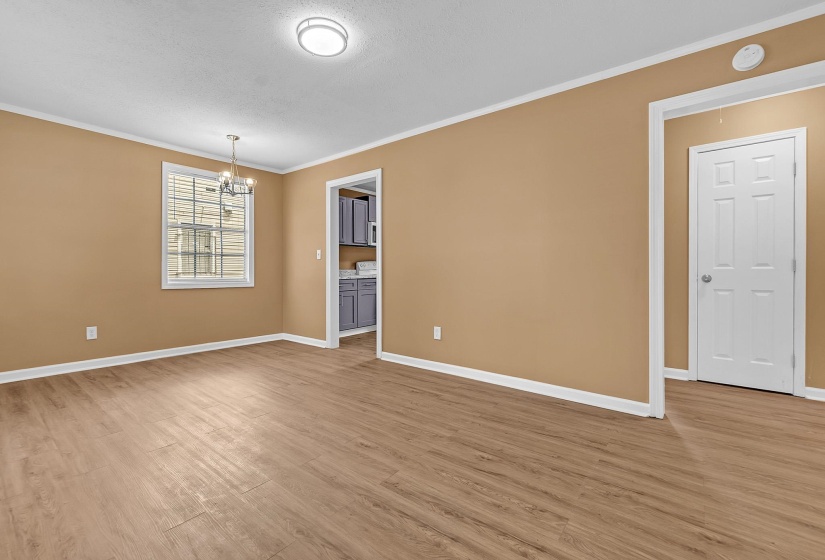 Spacious room featuring wood-finish flooring, neutral-toned walls, and white baseboards