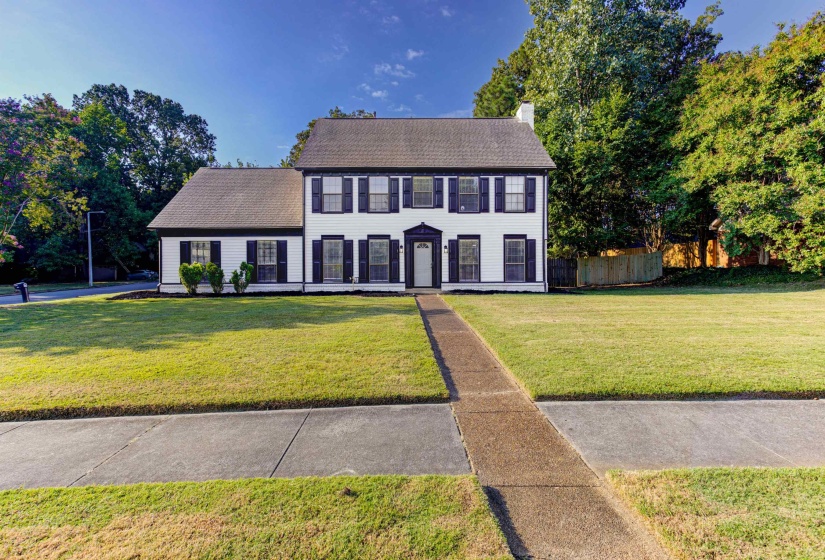 Colonial home with a chimney and a shingled roof