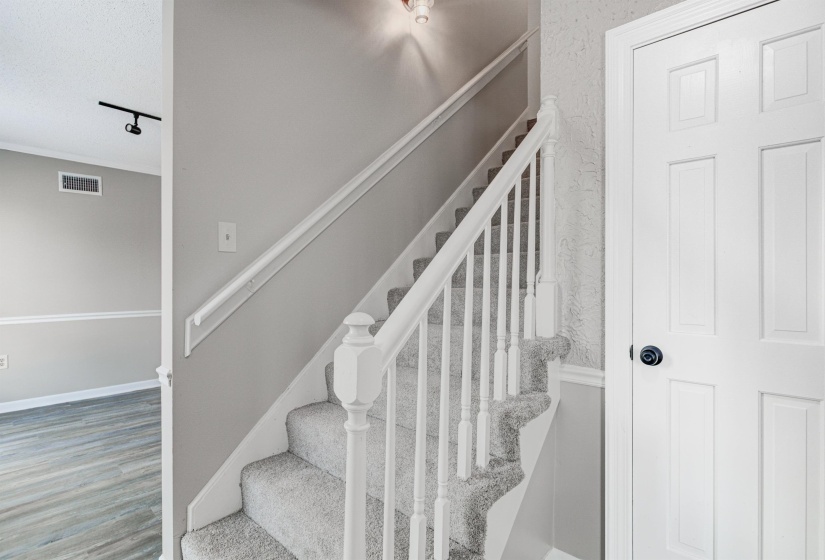 Stairs with wood finished floors and baseboards