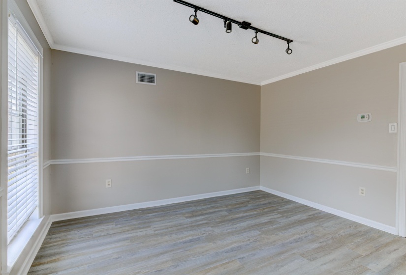 Spare room featuring crown molding, light wood-style floors, and rail lighting