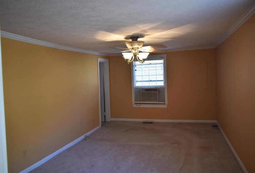 Empty room with carpet flooring, ornamental molding, a ceiling fan, and a textured ceiling