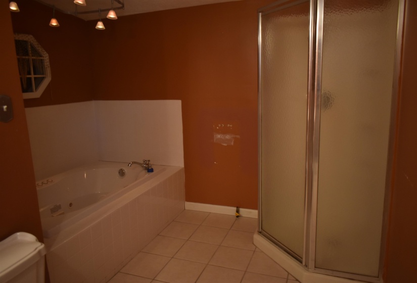 Full bath with a shower stall, light tile patterned floors, and a garden tub