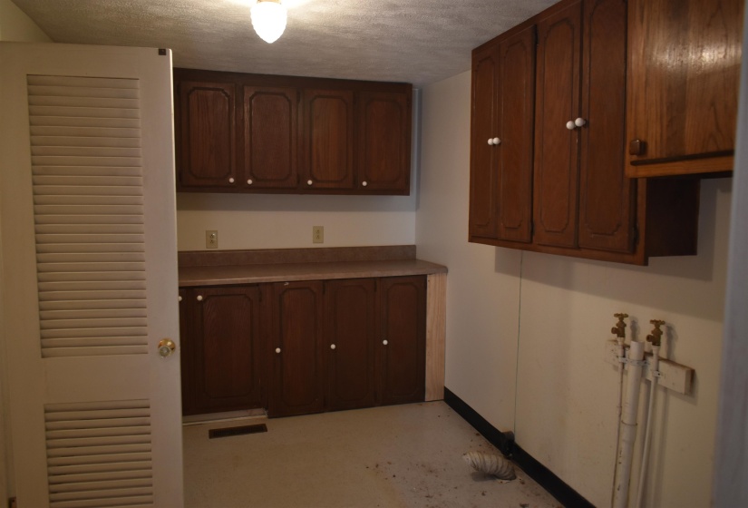 textured ceiling, light countertops, and concrete flooring