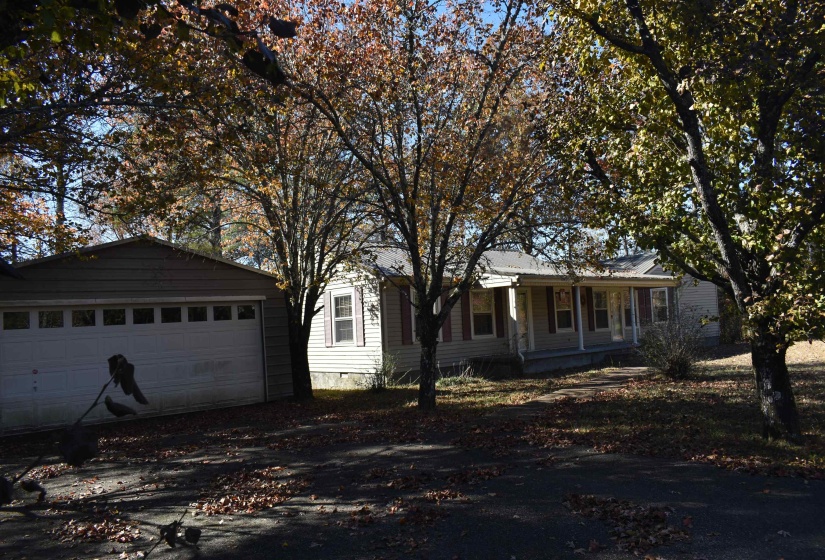 View of front of property featuring a porch and a detached garage