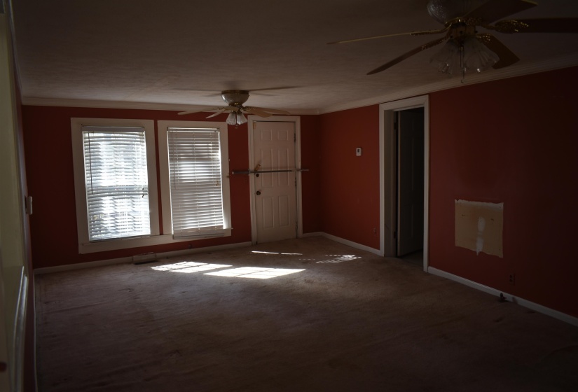 Carpeted spare room with ornamental molding and a ceiling fan