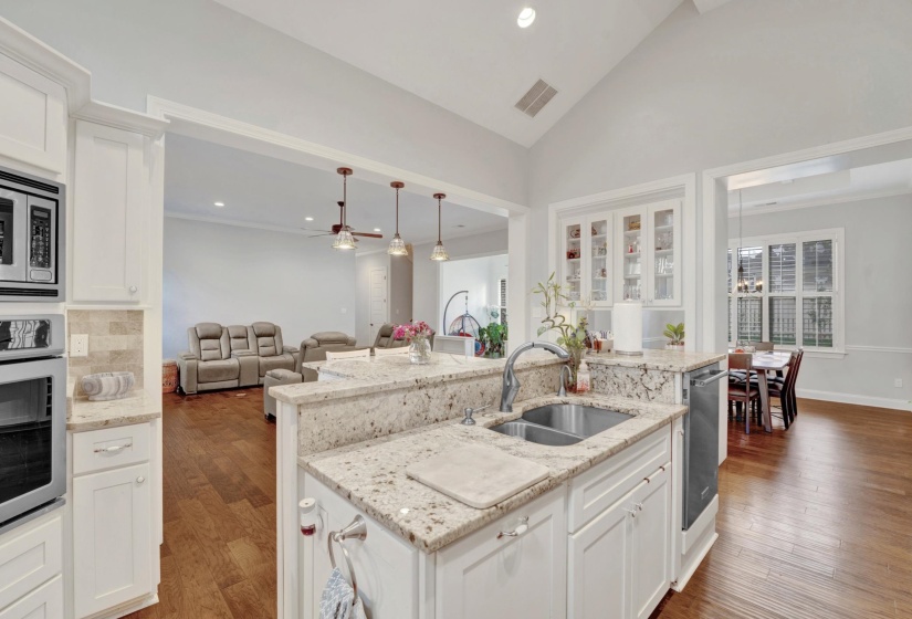 Kitchen featuring light-toned cabinetry and granite countertops with a double basin sink