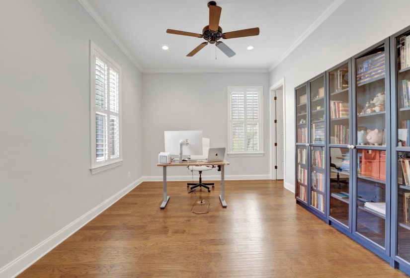 Interior room featuring wood-finish flooring, light gray walls, and crown molding