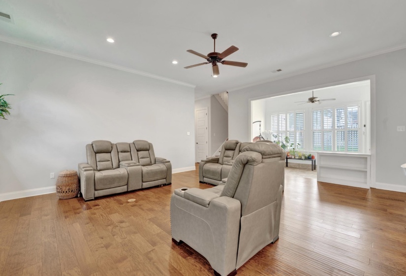 Spacious living area featuring wood-finish flooring, recessed lighting, and a ceiling fan