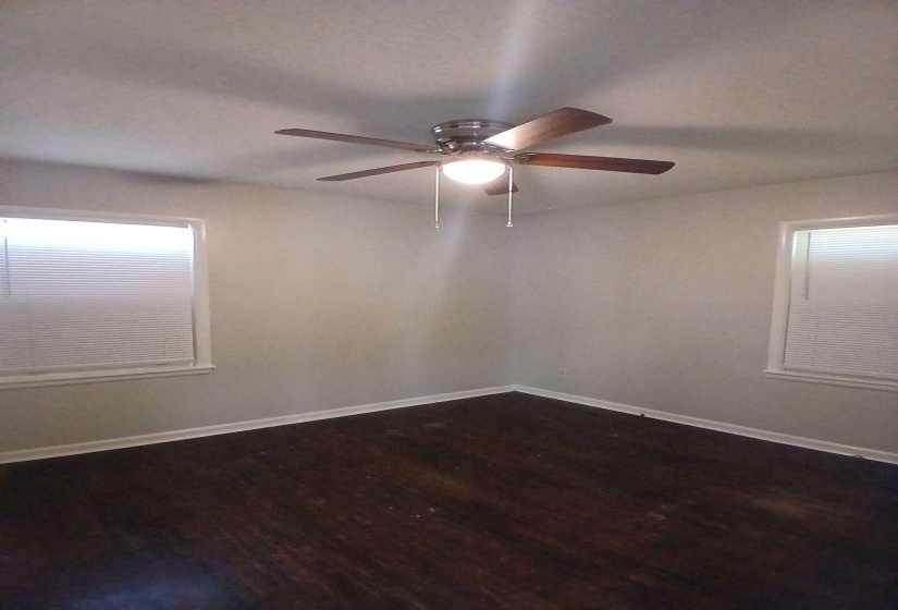 Room with dark wood-finish flooring, light-toned walls, and white baseboards