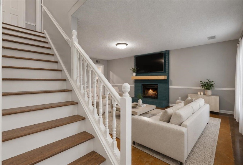 Staircase with wood-finish treads and white risers, featuring a white baluster railing system