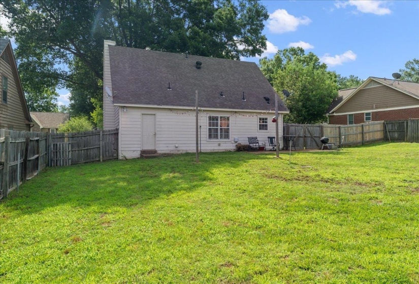 Expansive green lawn with a privacy fence surrounding the property