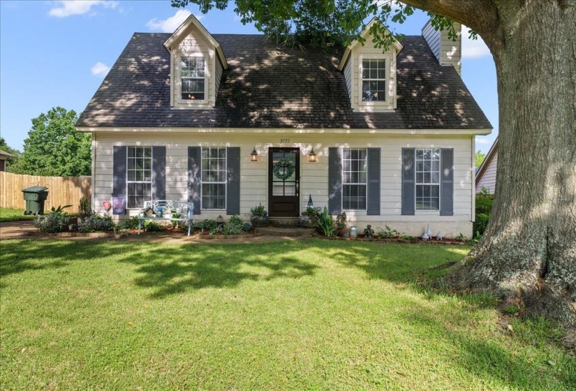 Traditional two-story residence featuring dormer windows, exterior siding, and dark shutters