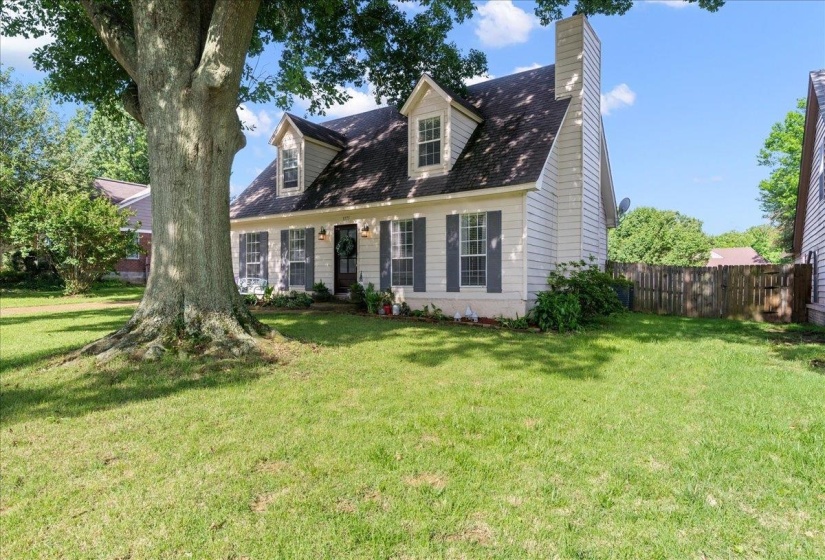 Traditional-style residence with prominent front-facing dormer windows, siding exterior, and a side chimney