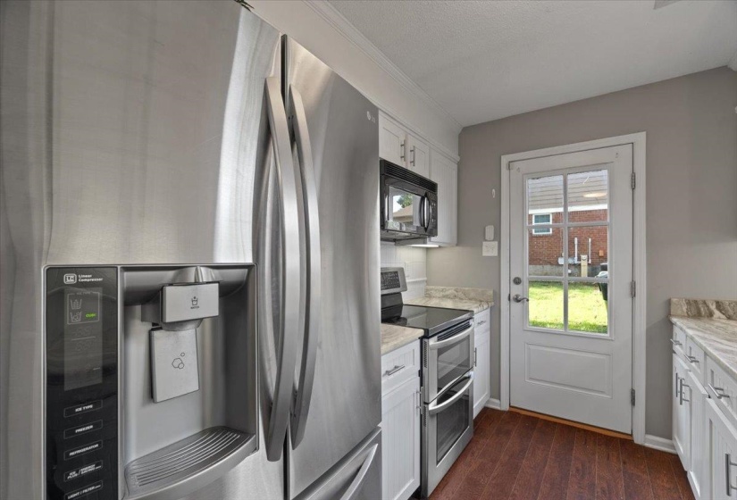 Stainless steel French door refrigerator with an integrated water and ice dispenser