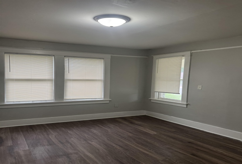 Room featuring wood-finish flooring, light grey painted walls, white trim, and a semi-flush ceiling light fixture
