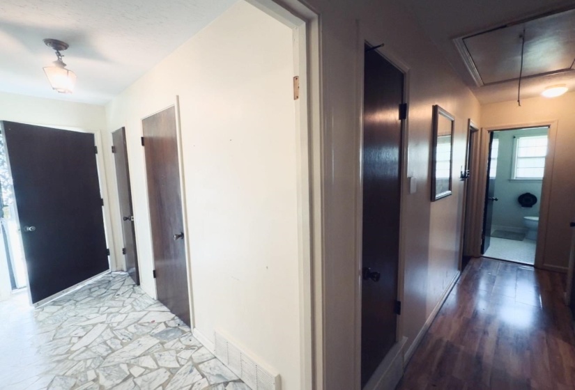 Entryway featuring mosaic-style floor tiling, a ceiling-mounted light fixture, and dark wood-paneled doors