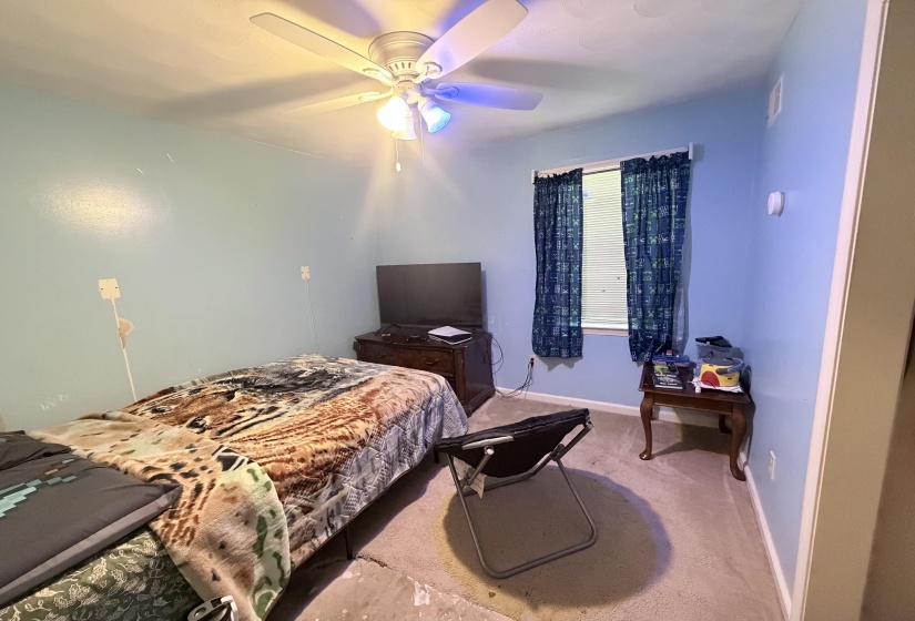 Room featuring a ceiling fan with integrated lighting, a window with blinds, and light blue wall finishes