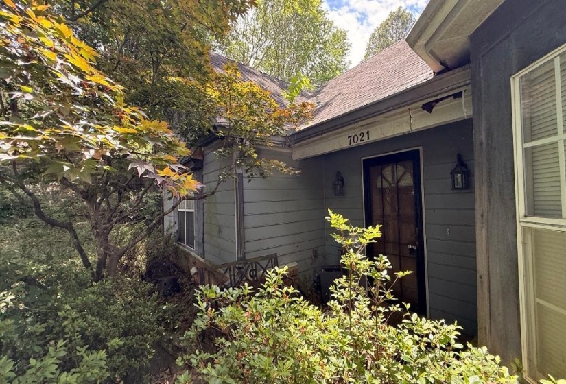 Front entrance featuring a dark wood door with decorative metalwork, flanked by two outdoor wall lanterns