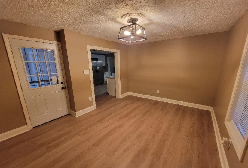 Spacious room featuring wood-finish flooring, neutral wall tones, and white trim
