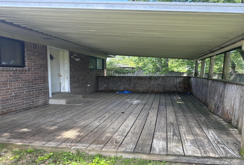 Wooden terrace featuring a carport