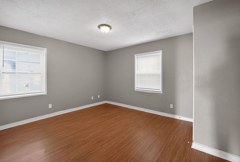 Unfurnished room featuring a textured ceiling and dark wood-style floors