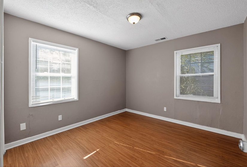 Spare room featuring dark wood-style flooring and a textured ceiling