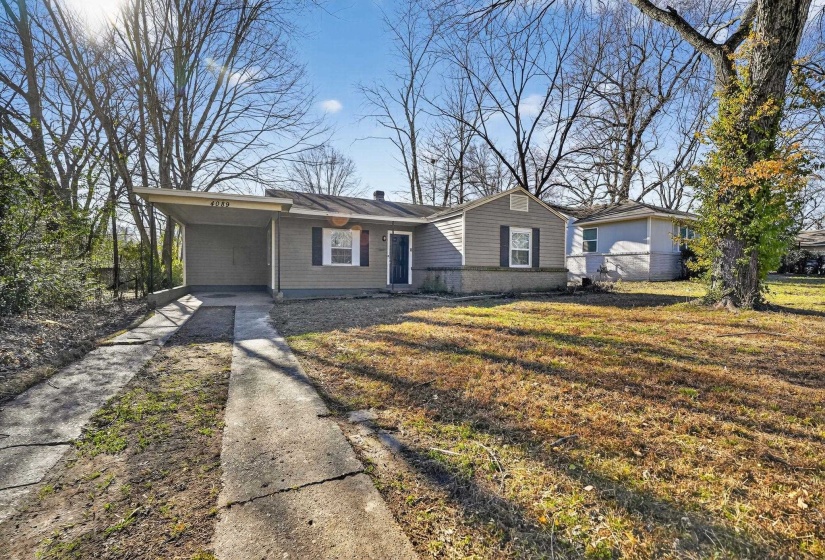 Single story home with a front lawn, a carport, and driveway