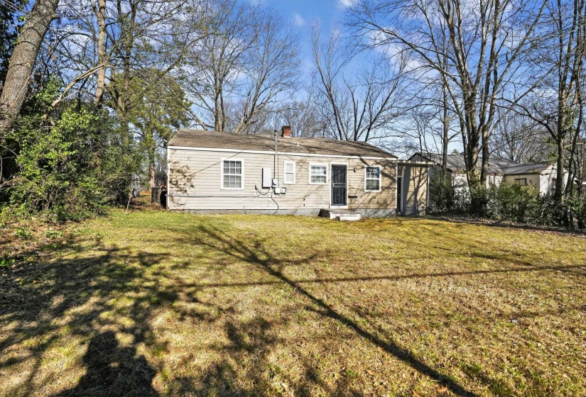 Back of house featuring a lawn and a chimney