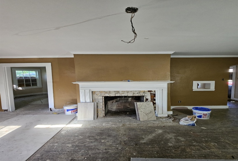 Central fireplace with a white mantel and exposed brick firebox