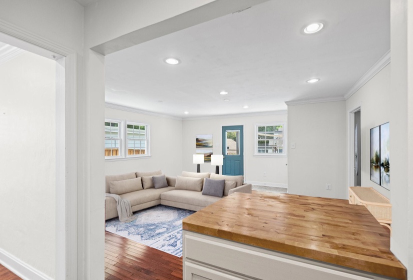 Open-concept living space featuring wood-finish flooring, recessed lighting, and white trim molding