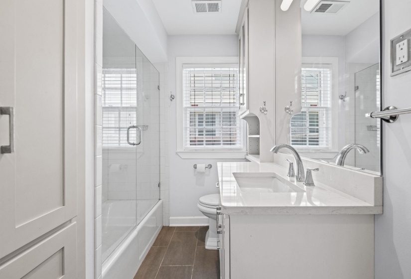 Bathroom featuring a white vanity with an integrated sink, polished chrome fixtures, and a white countertop