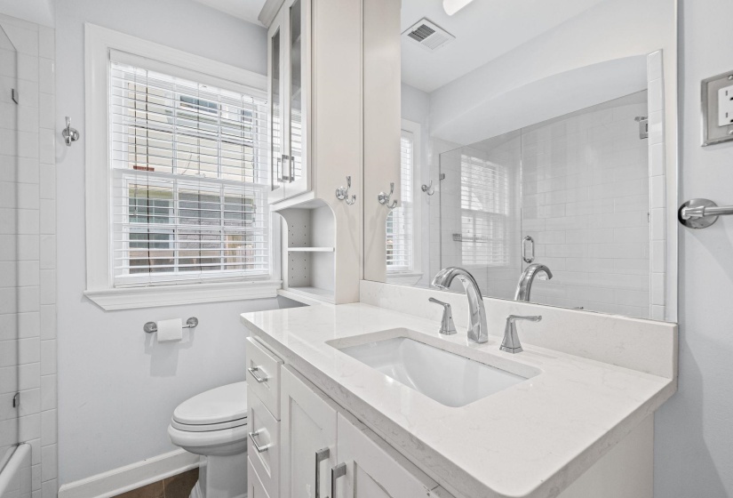 Contemporary bathroom vanity featuring a white undermount sink, a light-toned countertop, and chrome fixtures