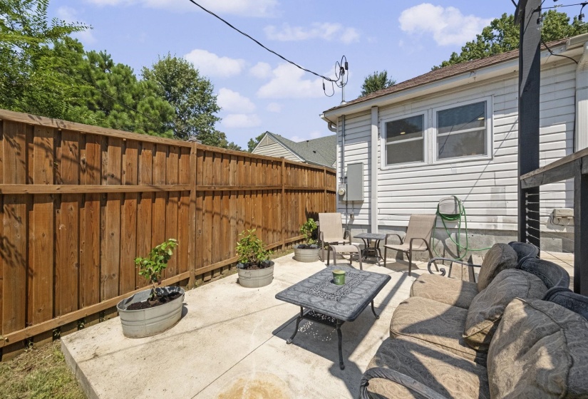 Concrete patio with a full privacy fence