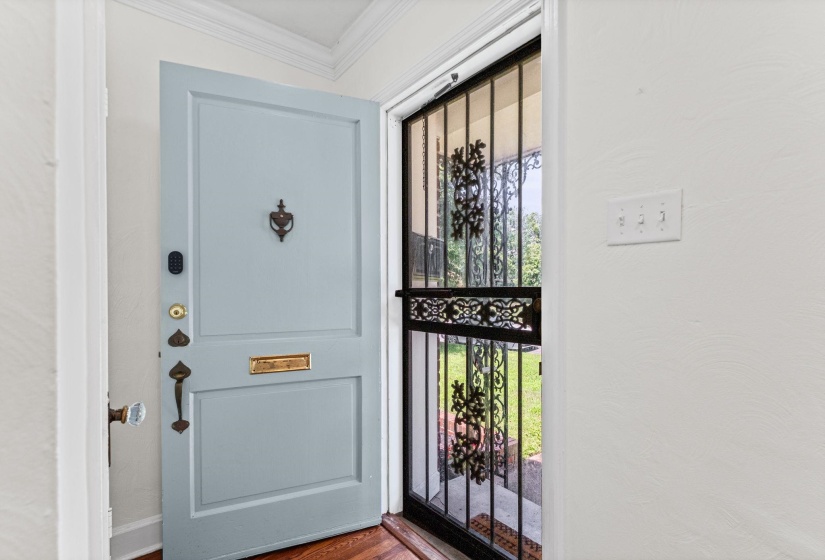 Front entry featuring a light blue paneled door with brass hardware and a decorative knocker