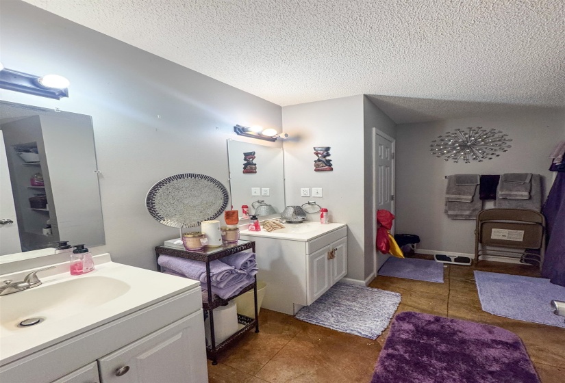 Bathroom featuring two white vanities with integrated sinks, each with a polished chrome faucet